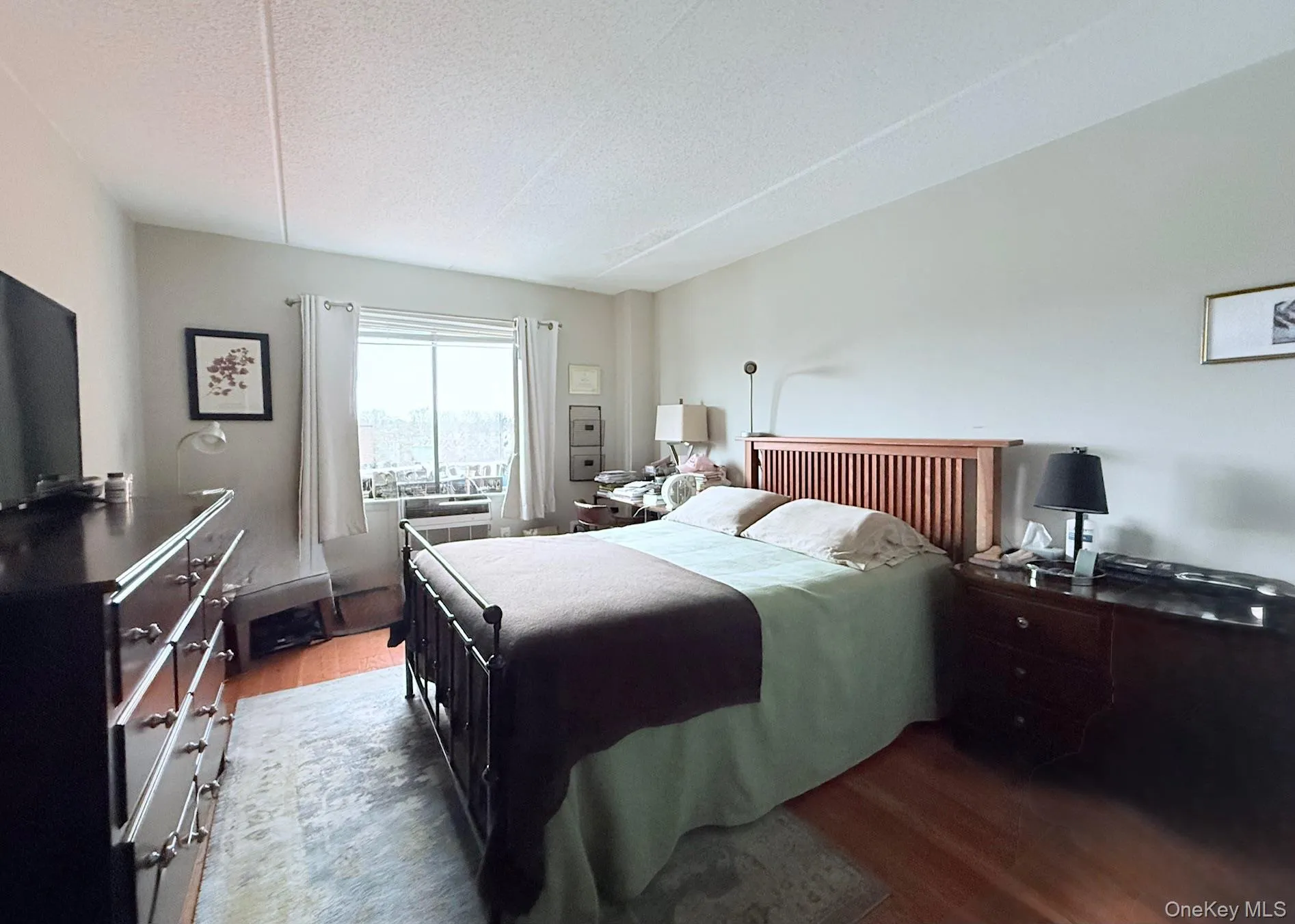 Bedroom with wood finished floors and a textured ceiling Bedroom with wood finished floors and a textured ceiling