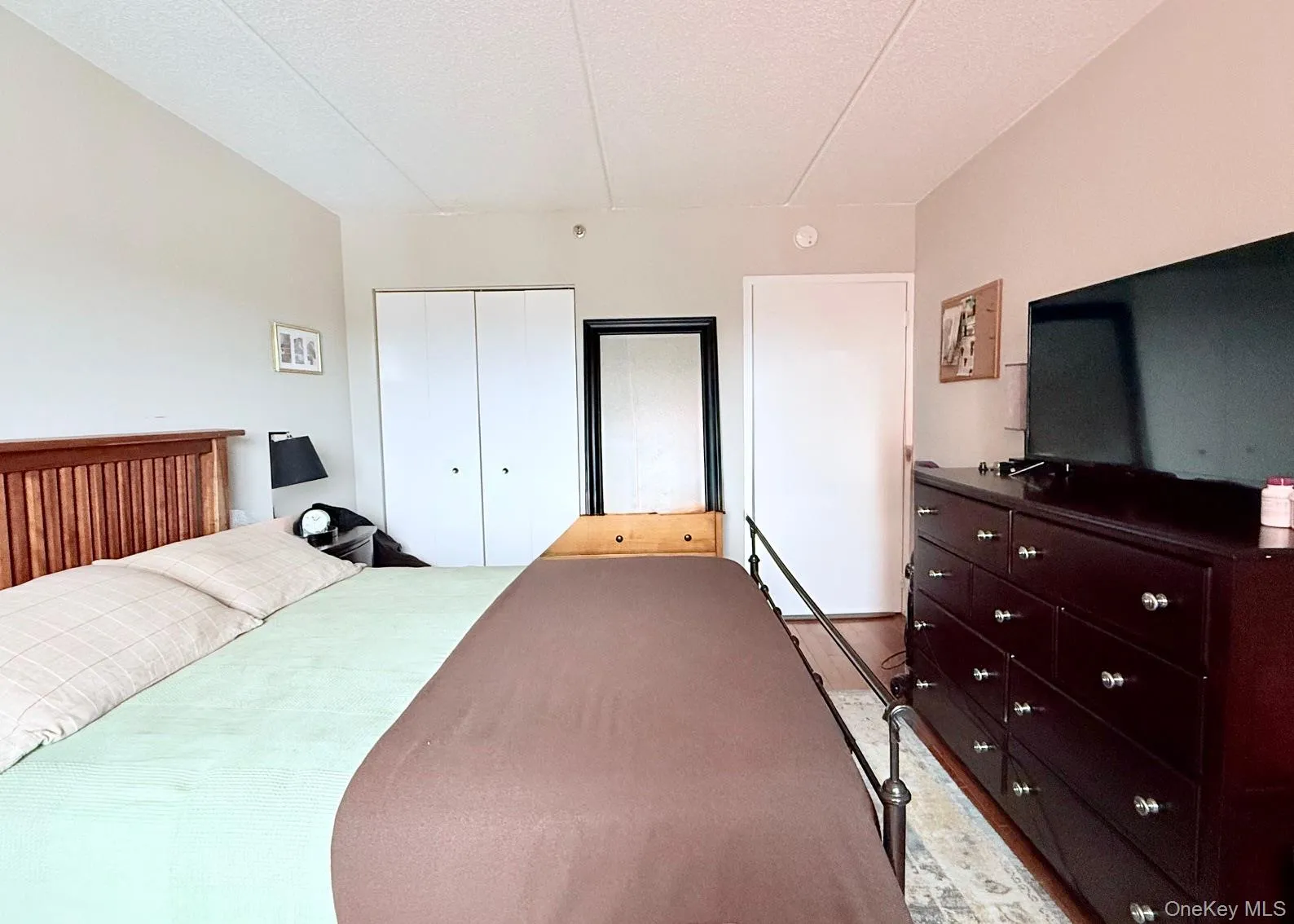 Bedroom featuring a closet, a textured ceiling, and light wood-style flooring Bedroom featuring a closet, a textured ceiling, and light wood-style flooring