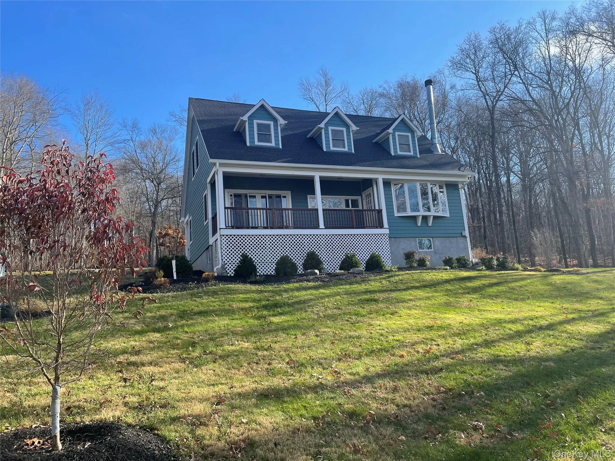Cape cod house with covered porch and a front lawn Cape cod house with covered porch and a front lawn