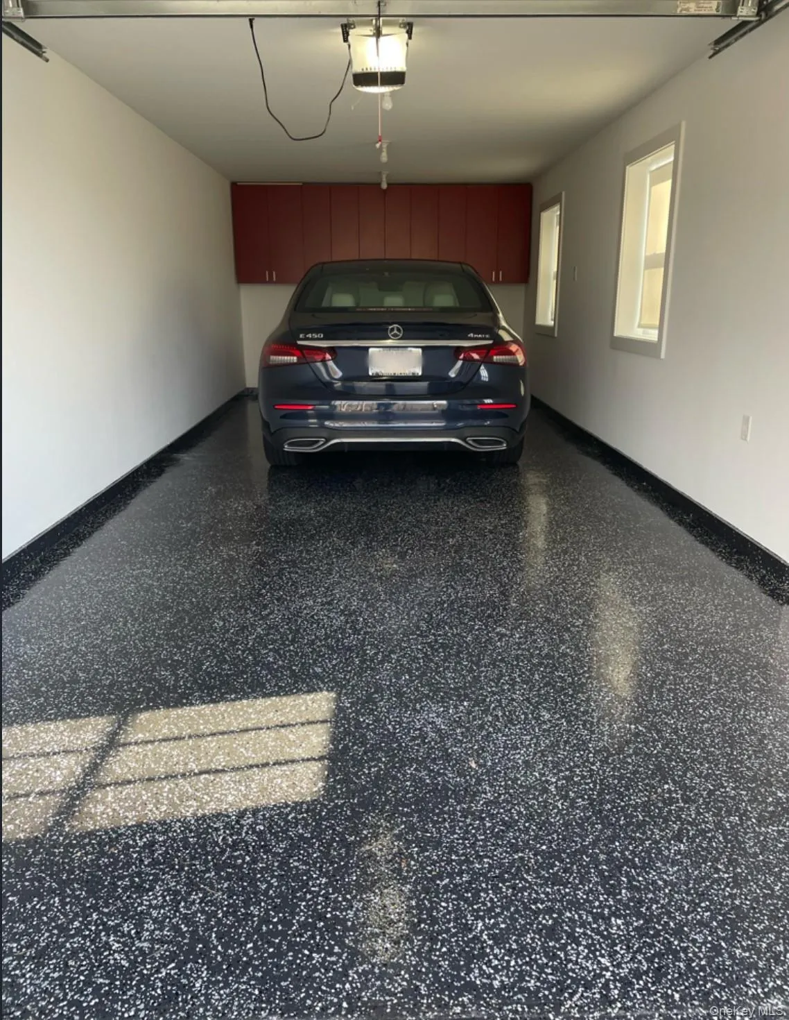 Garage with baseboards and a garage door opener Garage with baseboards and a garage door opener