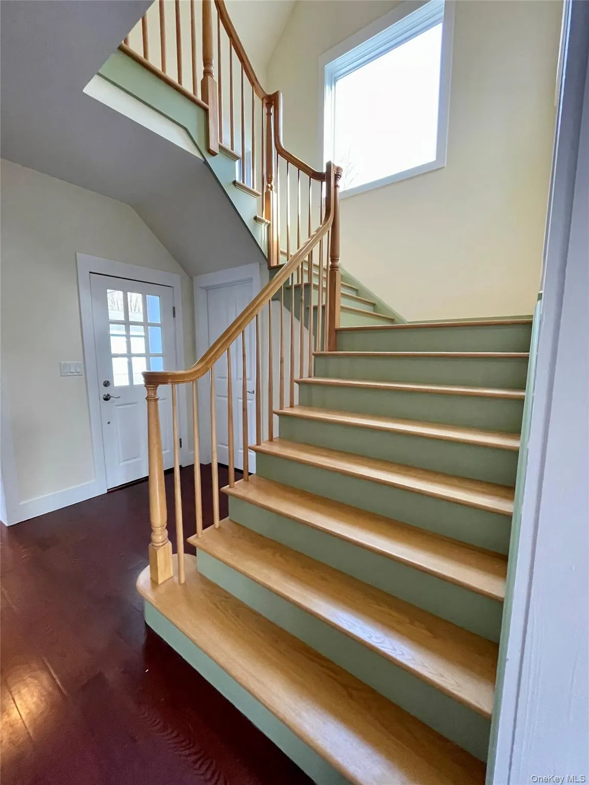 Stairway featuring wood finished floors and vaulted ceiling Stairway featuring wood finished floors and vaulted ceiling