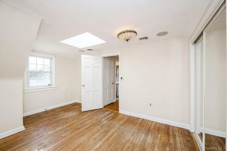 Spare room featuring light wood finished floors and a skylight Spare room featuring light wood finished floors and a skylight