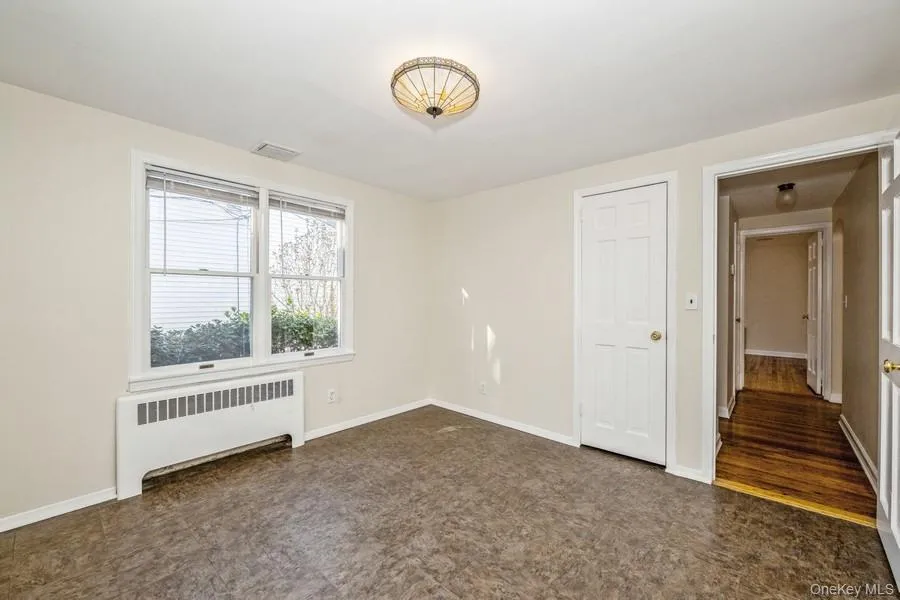Spare room featuring radiator heating unit and baseboards Spare room featuring radiator heating unit and baseboards