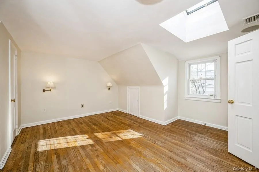 Bonus room with a skylight, hardwood / wood-style floors, and lofted ceiling Bonus room with a skylight, hardwood / wood-style floors, and lofted ceiling