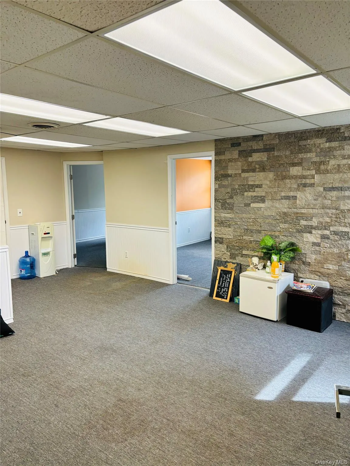 Common Area of offices B and C. Featuring a wainscoted wall, a drop ceiling, and carpet floors Common Area of offices B and C. Featuring a wainscoted wall, a drop ceiling, and carpet floors