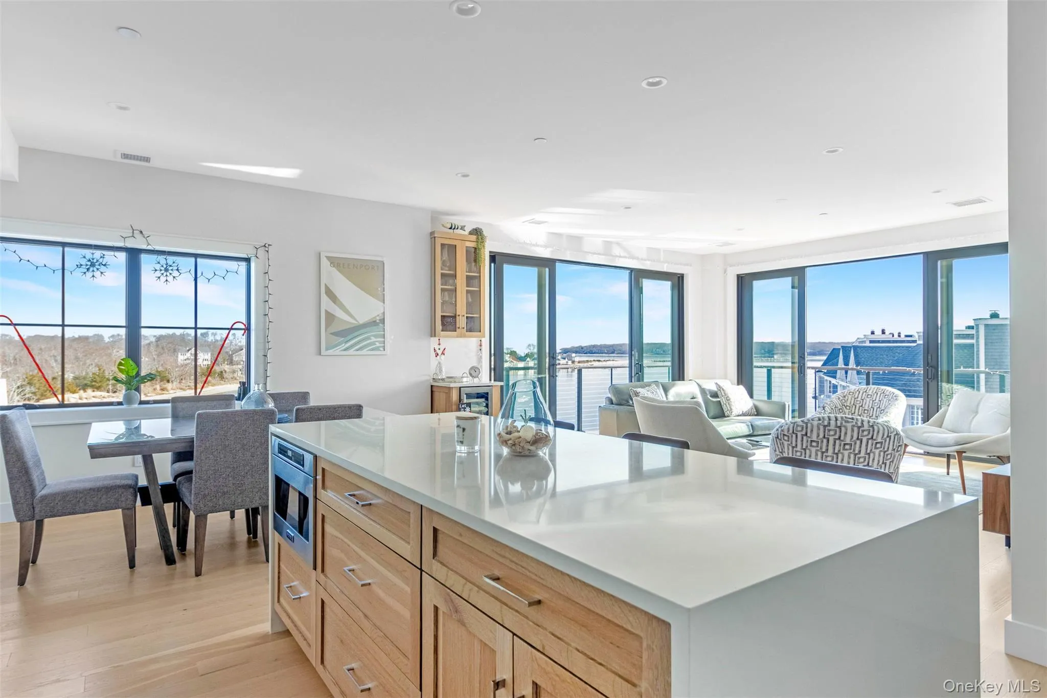 Kitchen with a center island, light wood-style floors, glass insert cabinets, open floor plan, and recessed lighting Kitchen with a center island, light wood-style floors, glass insert cabinets, open floor plan, and recessed lighting