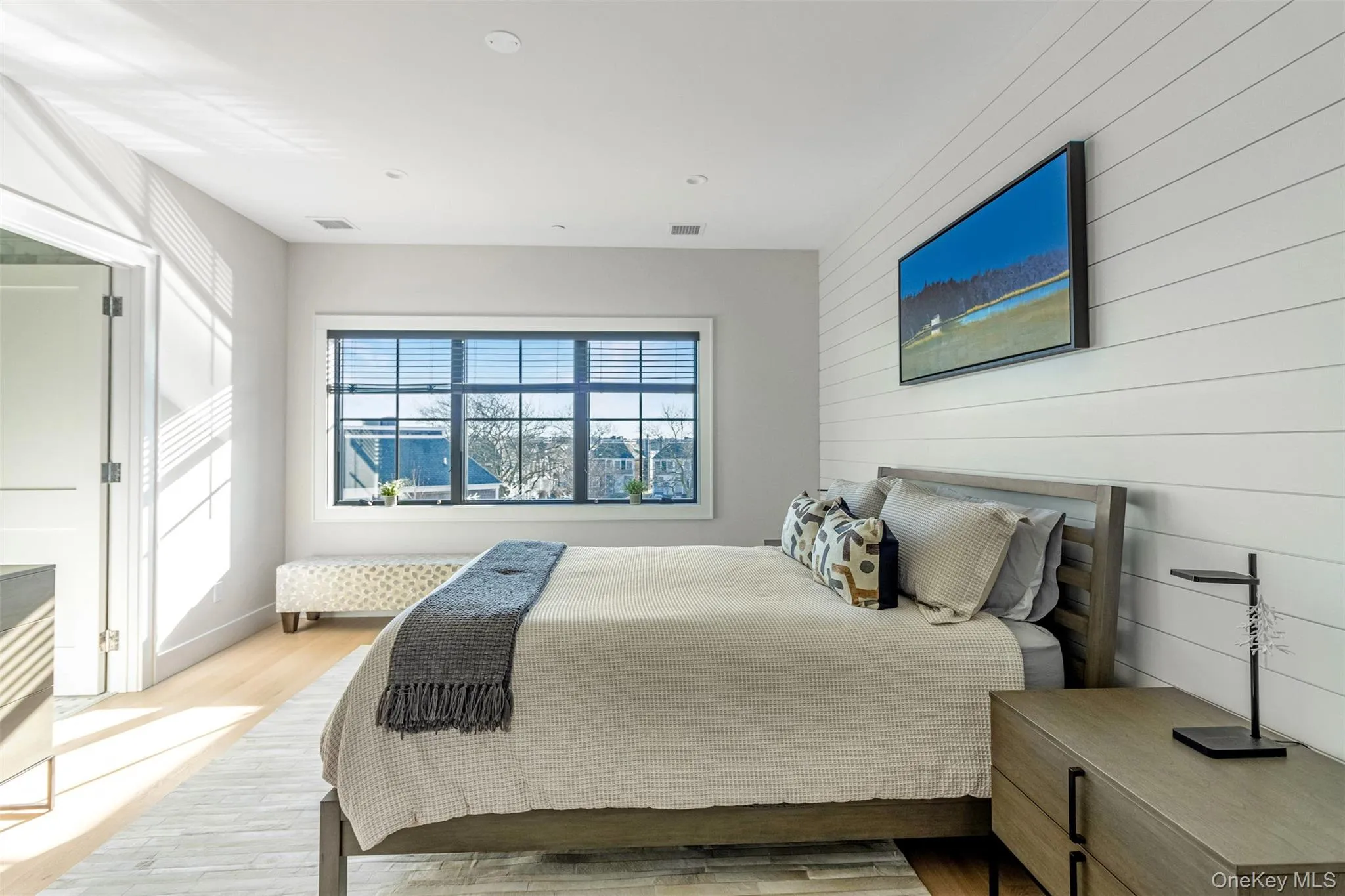 Bedroom featuring light wood-type flooring and wooden walls Bedroom featuring light wood-type flooring and wooden walls