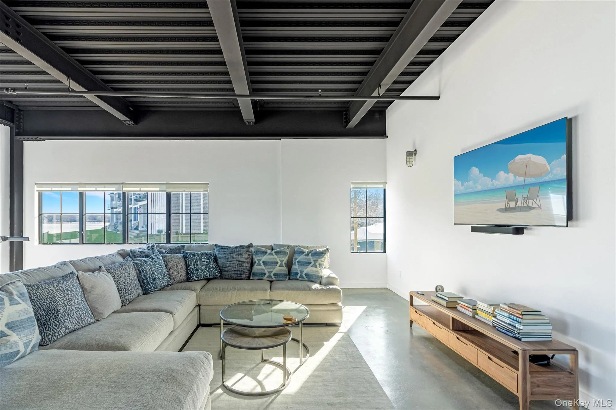 Living room featuring beam ceiling and finished concrete floors Living room featuring beam ceiling and finished concrete floors