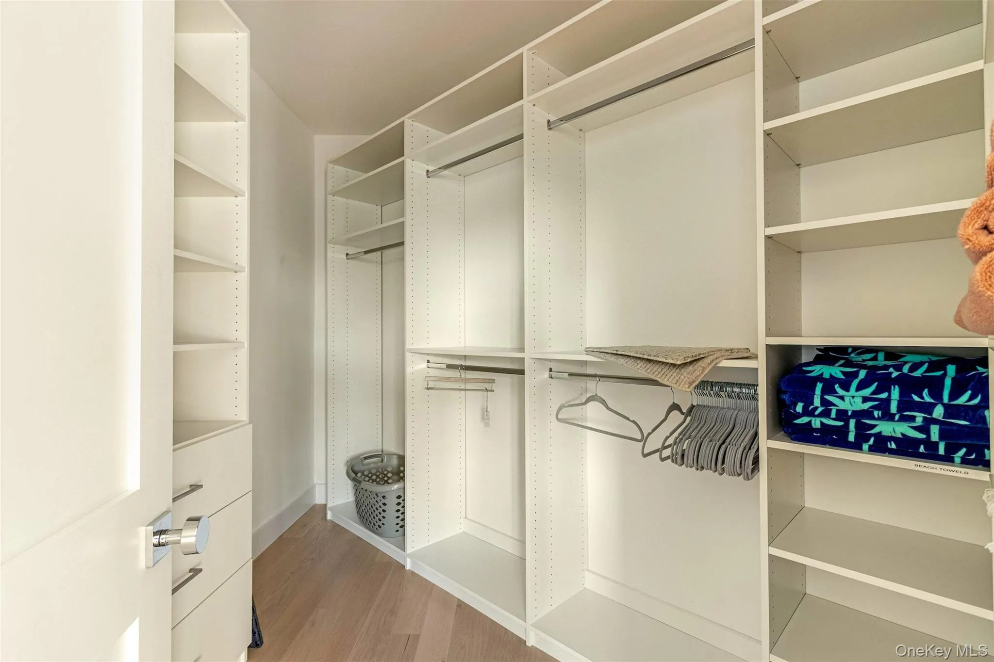 Walk in closet with light wood-type flooring Walk in closet with light wood-type flooring