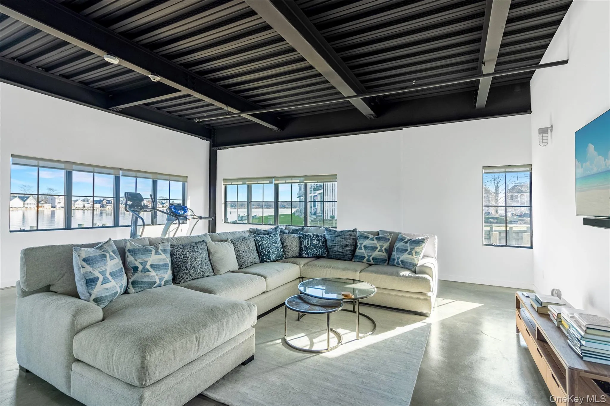 Living room with finished concrete flooring and beam ceiling Living room with finished concrete flooring and beam ceiling