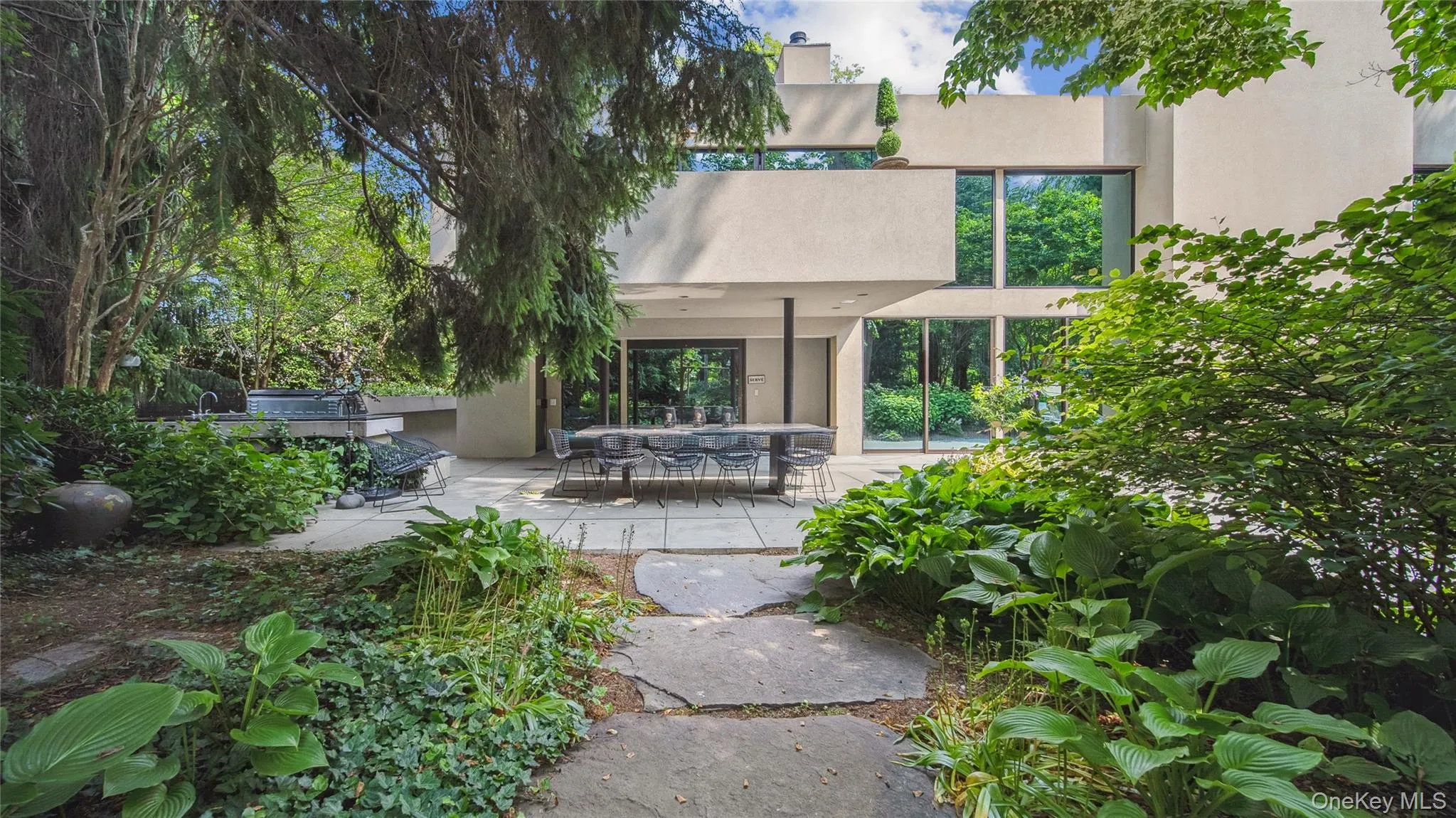 Rear view of house with stucco siding, a patio area, and a pergola Rear view of house with stucco siding, a patio area, and a pergola