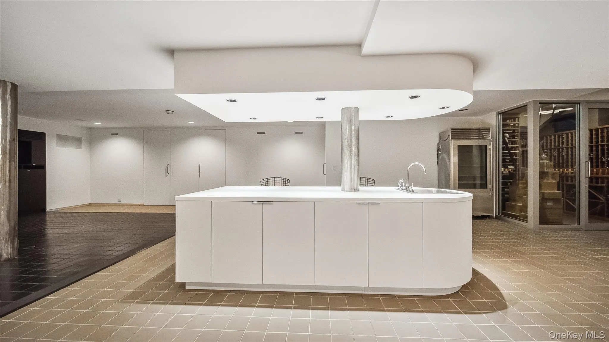 Kitchen with modern cabinets, white cabinetry, light countertops, and an island with sink Kitchen with modern cabinets, white cabinetry, light countertops, and an island with sink