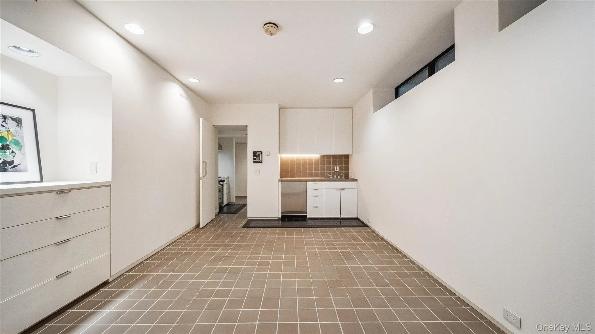 Kitchen featuring white cabinets, recessed lighting, decorative backsplash, and light countertops Kitchen featuring white cabinets, recessed lighting, decorative backsplash, and light countertops