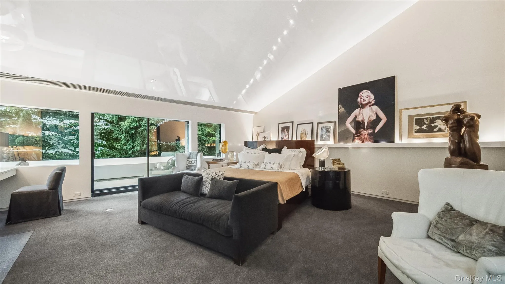 Primary Bedroom Featuring Custom Wool Carpet, High Vaulted Ceilings, and Sliders To Private Balcony Primary Bedroom Featuring Custom Wool Carpet, High Vaulted Ceilings, and Sliders To Private Balcony