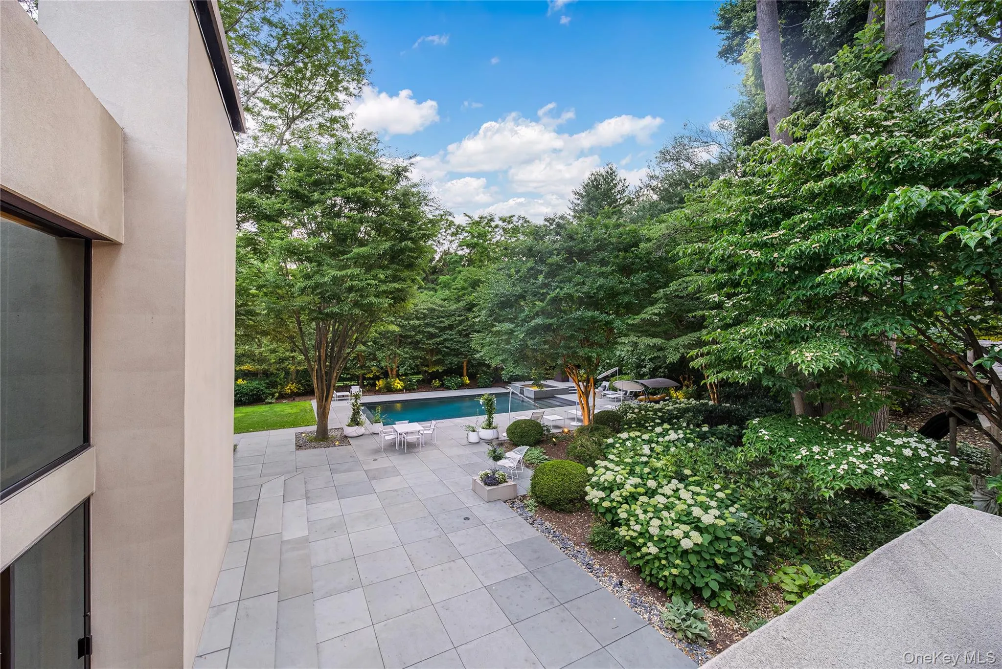 View of patio with an outdoor pool and view of scattered trees View of patio with an outdoor pool and view of scattered trees