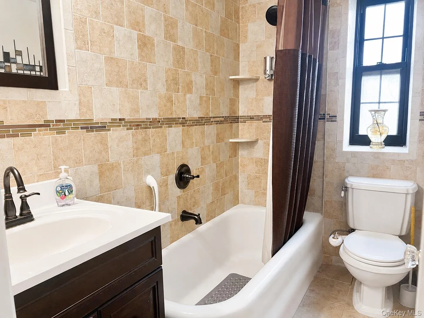 Full bath with vanity, tile walls, and shower / bath combination with curtain Full bath with vanity, tile walls, and shower / bath combination with curtain