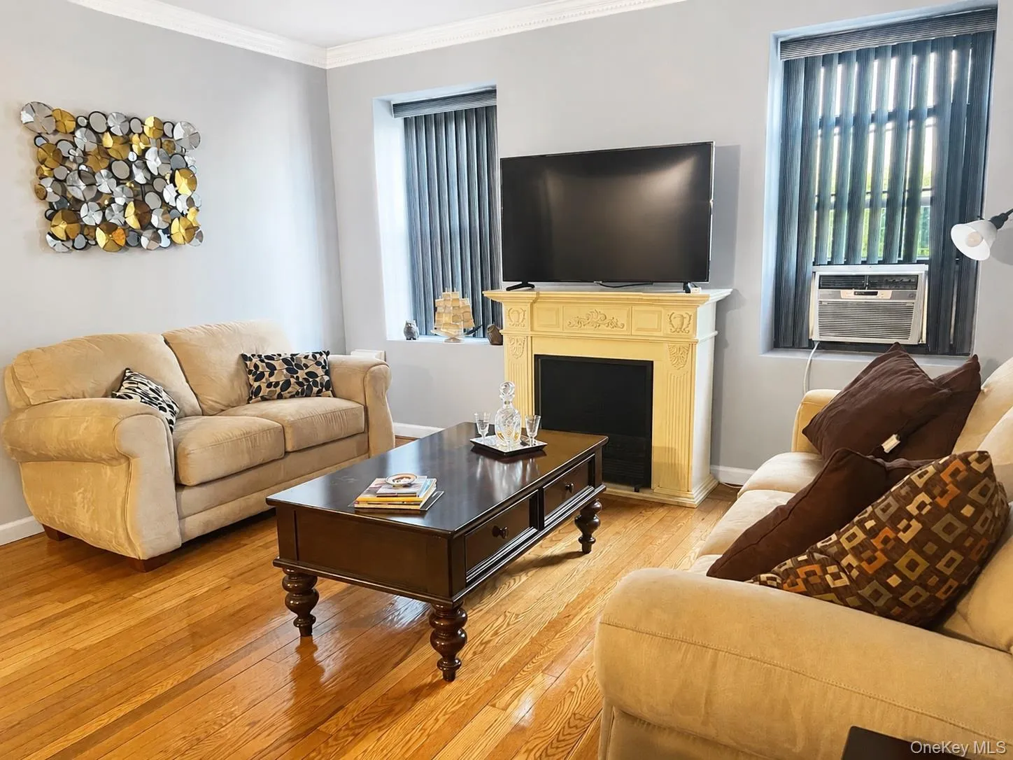 Living room with a decorative fireplace, hardwood floors crown molding Living room with a decorative fireplace, hardwood floors crown molding