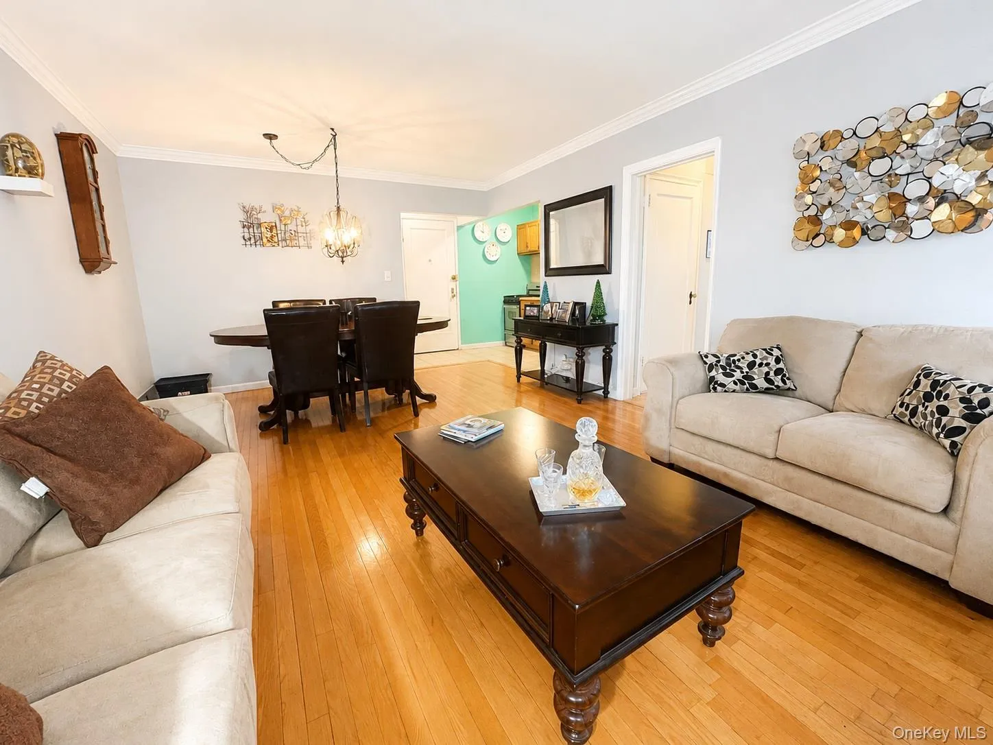 Living room featuring hardwood floors and crown molding Living room featuring hardwood floors and crown molding