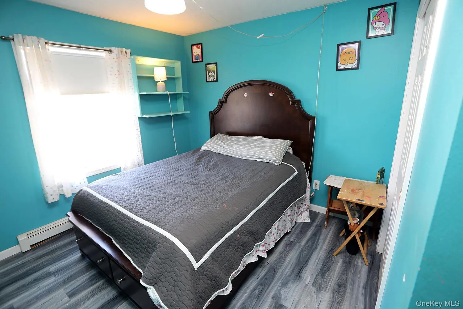 Bedroom featuring baseboard heating and dark wood-style flooring Bedroom featuring baseboard heating and dark wood-style flooring