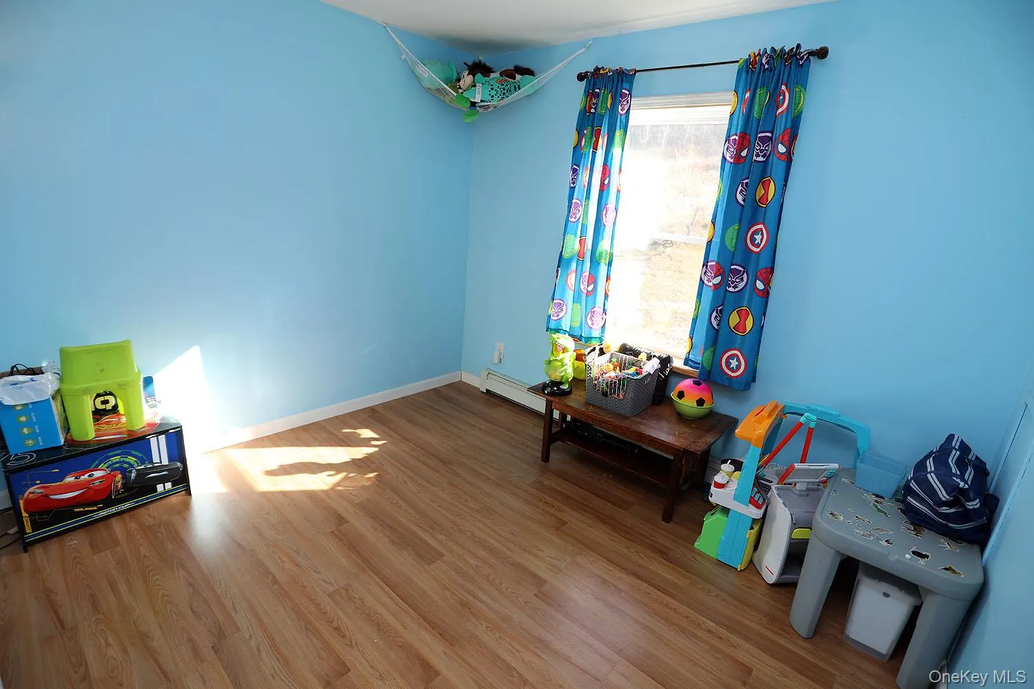 Game room featuring wood finished floors and a baseboard heating unit Game room featuring wood finished floors and a baseboard heating unit