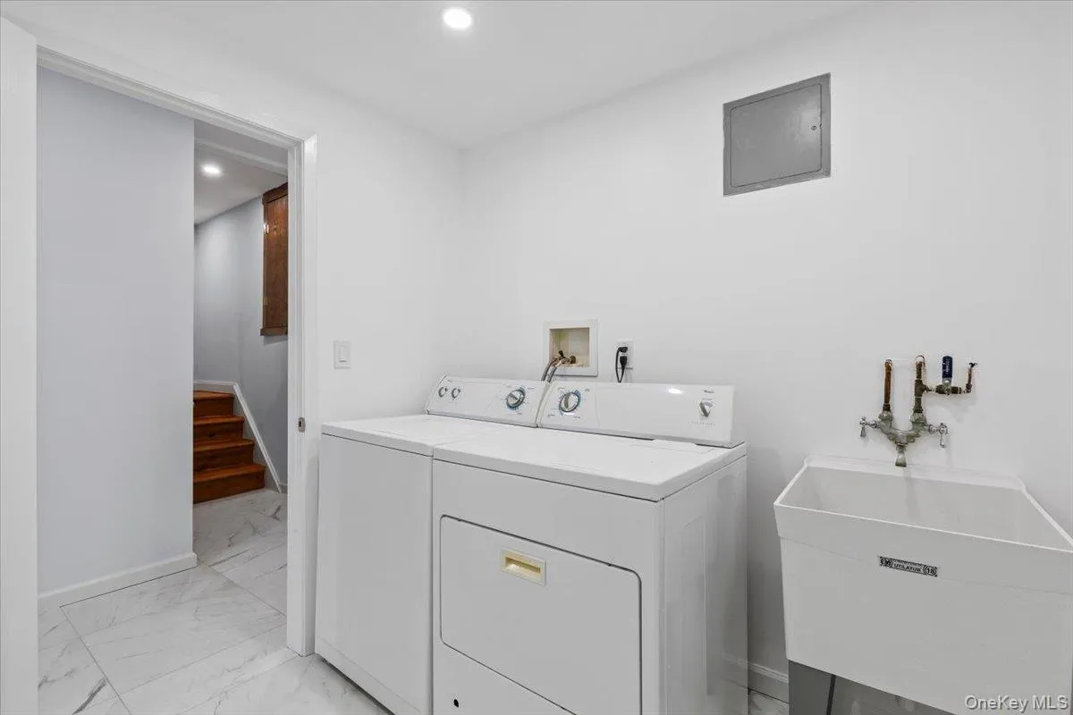 Laundry room with light marble finish flooring, recessed lighting, electric panel, and washer and clothes dryer Laundry room with light marble finish flooring, recessed lighting, electric panel, and washer and clothes dryer