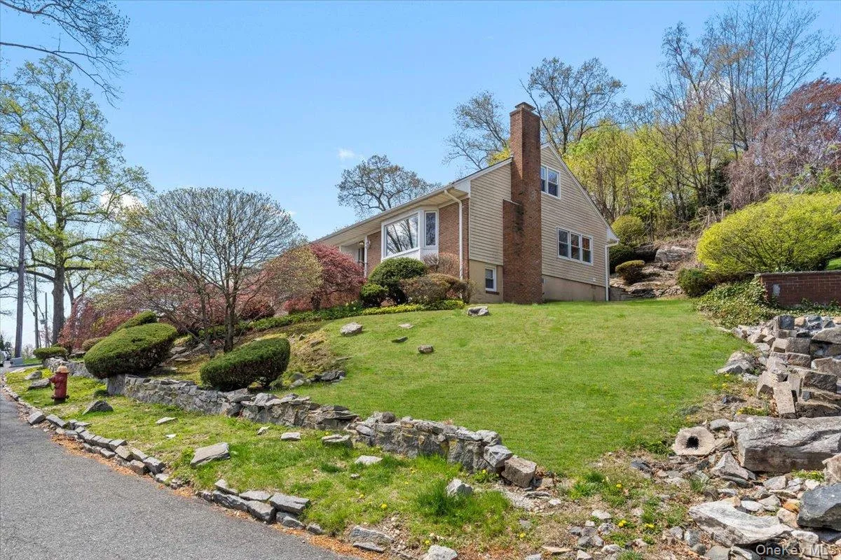 View of home's exterior with a chimney and a yard View of home's exterior with a chimney and a yard