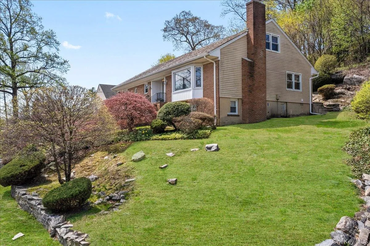 View of side of property with a chimney and a lawn View of side of property with a chimney and a lawn
