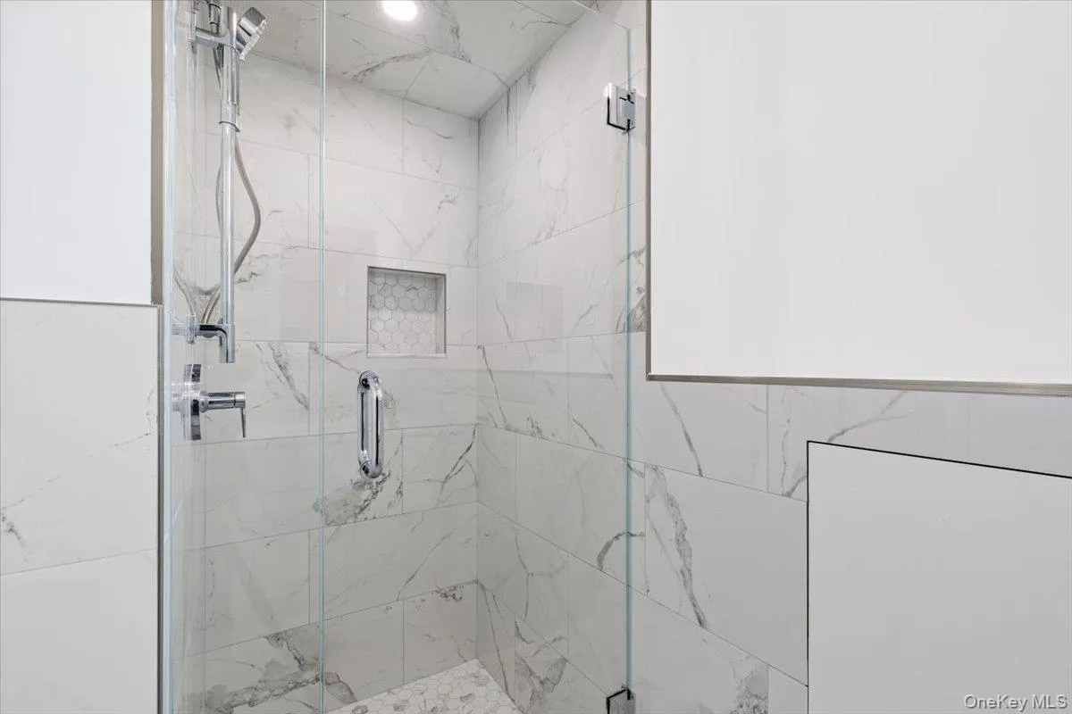 Bathroom featuring a marble finish shower Bathroom featuring a marble finish shower