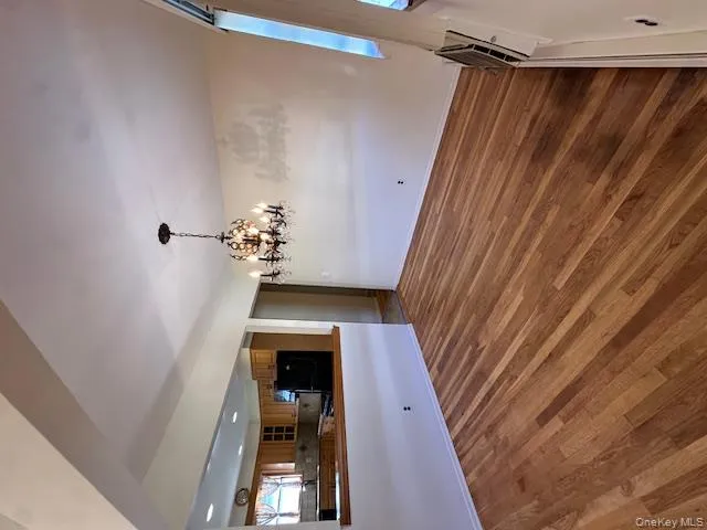 Unfurnished dining area featuring dark wood finished floors and a chandelier Unfurnished dining area featuring dark wood finished floors and a chandelier