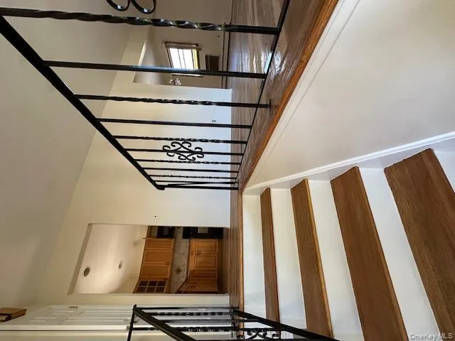 Stairs featuring a baseboard heating unit and wood finished floors Stairs featuring a baseboard heating unit and wood finished floors