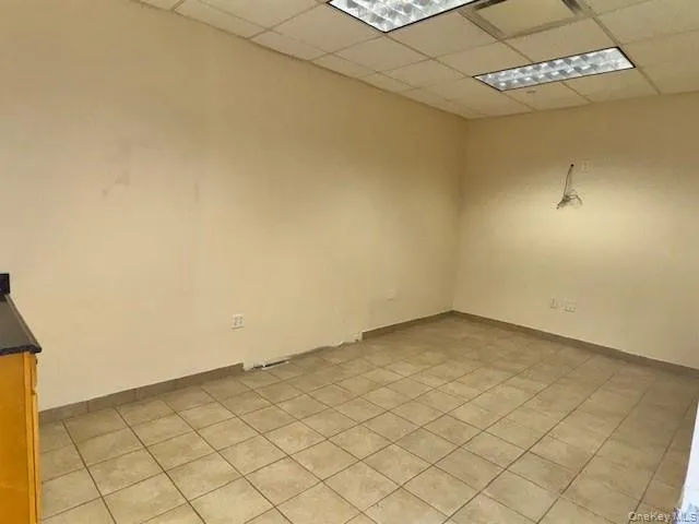 Spare room with a paneled ceiling and light tile patterned floors Spare room with a paneled ceiling and light tile patterned floors
