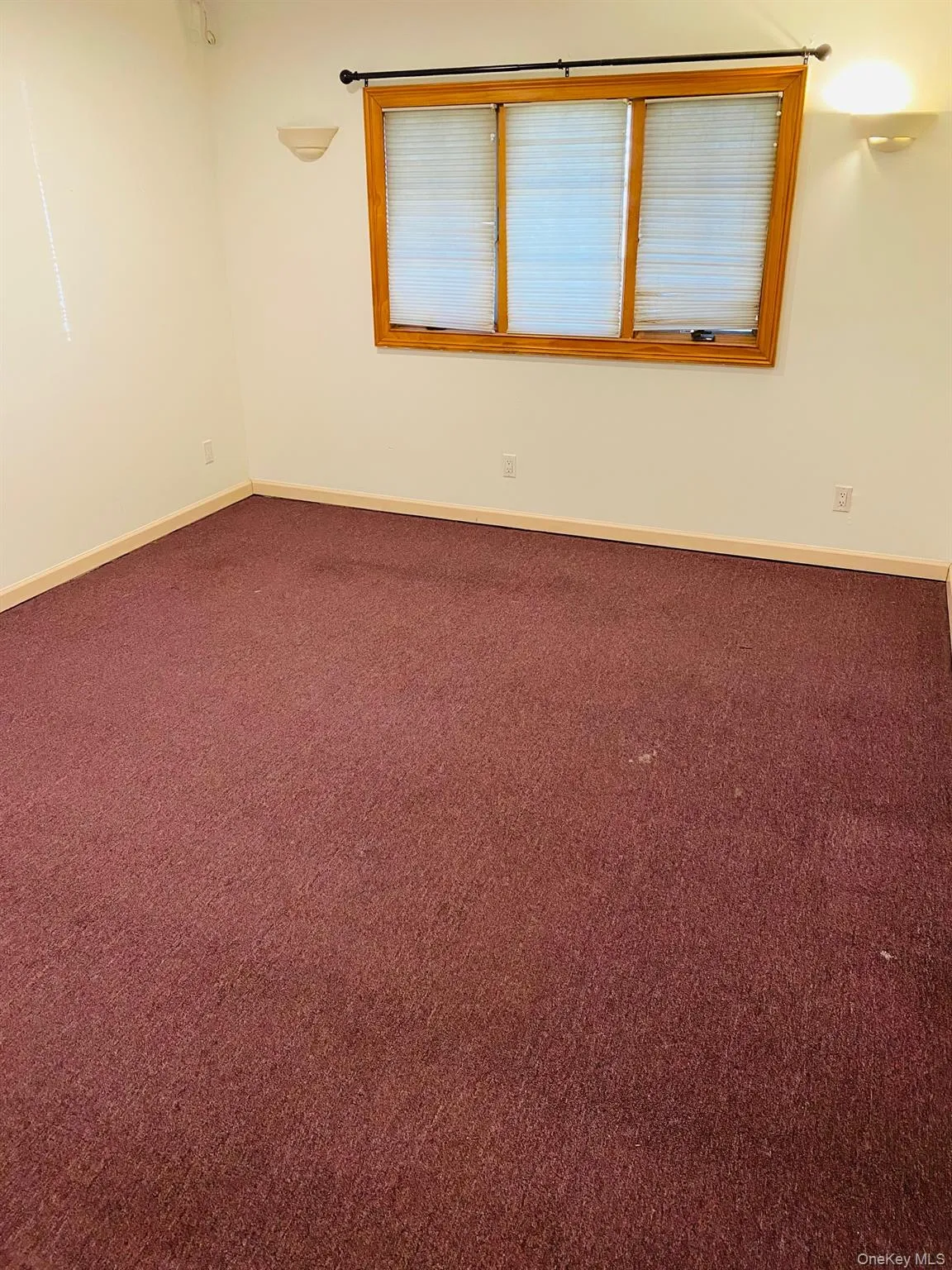 Unfurnished room with dark colored carpet and baseboards Unfurnished room with dark colored carpet and baseboards