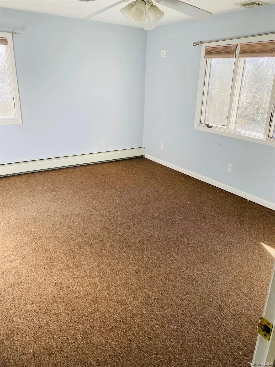 Spare room featuring a baseboard radiator and carpet floors Spare room featuring a baseboard radiator and carpet floors