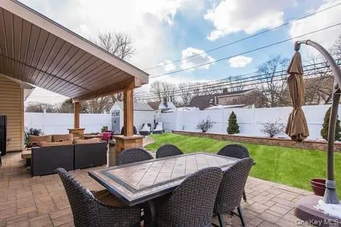 Fenced backyard with a patio area, outdoor dining space, outdoor lounge area, and a storage unit Fenced backyard with a patio area, outdoor dining space, outdoor lounge area, and a storage unit