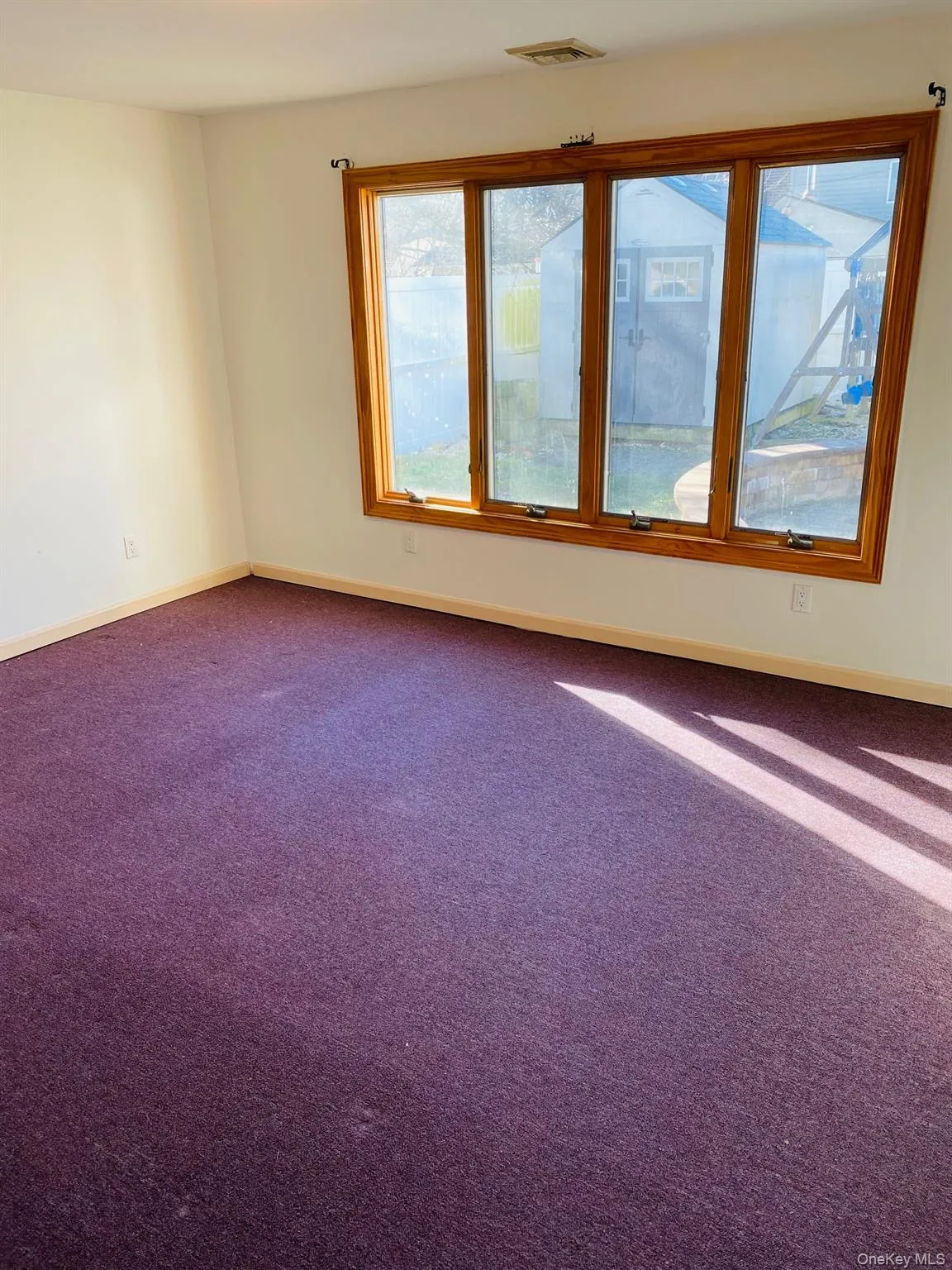 Spare room featuring dark colored carpet and baseboards Spare room featuring dark colored carpet and baseboards