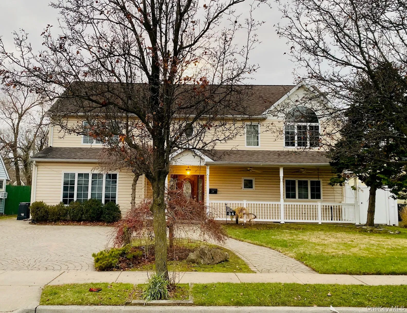 Traditional-style house with a porch, a front lawn, a ceiling fan, a shingled roof, and driveway Traditional-style house with a porch, a front lawn, a ceiling fan, a shingled roof, and driveway