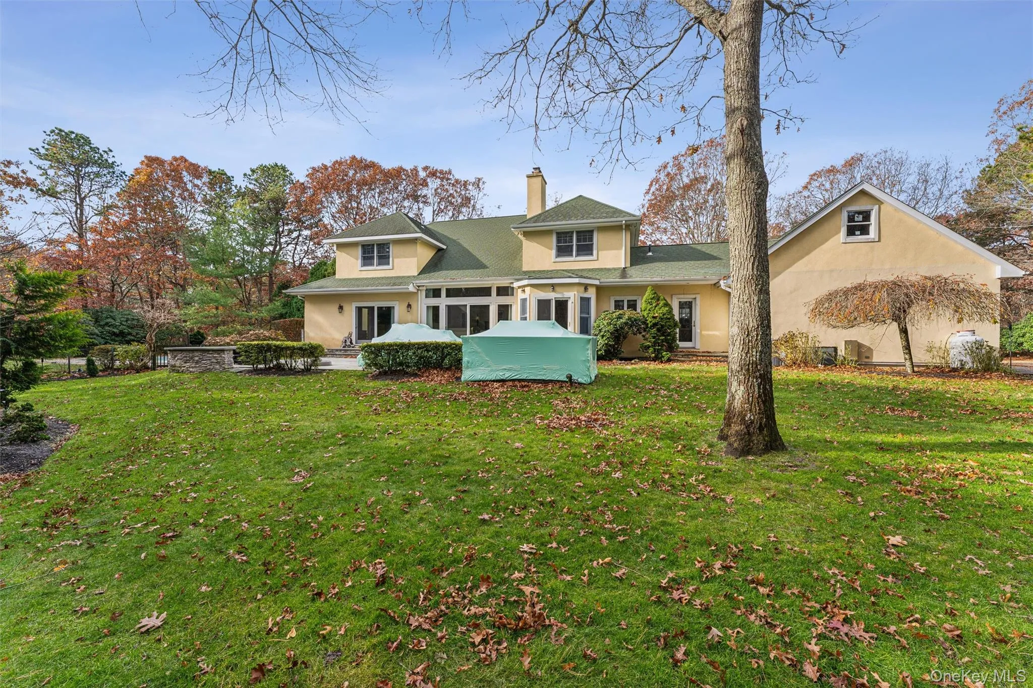 View of front of home with a front yard, a chimney, and stucco siding View of front of home with a front yard, a chimney, and stucco siding
