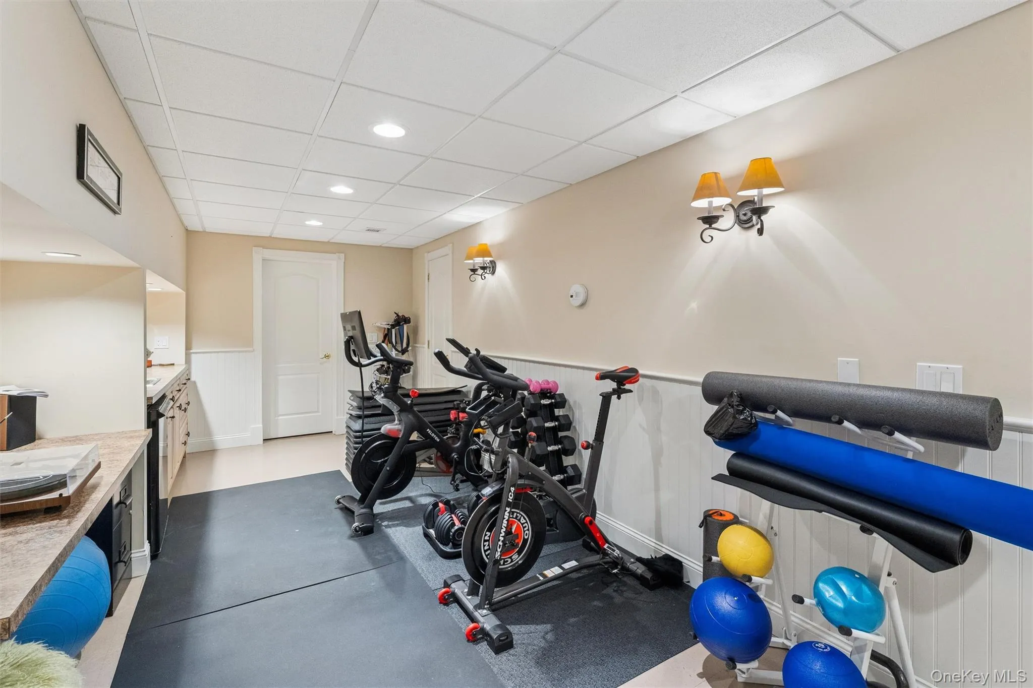 Exercise room featuring a wainscoted wall, a paneled ceiling, and recessed lighting Exercise room featuring a wainscoted wall, a paneled ceiling, and recessed lighting