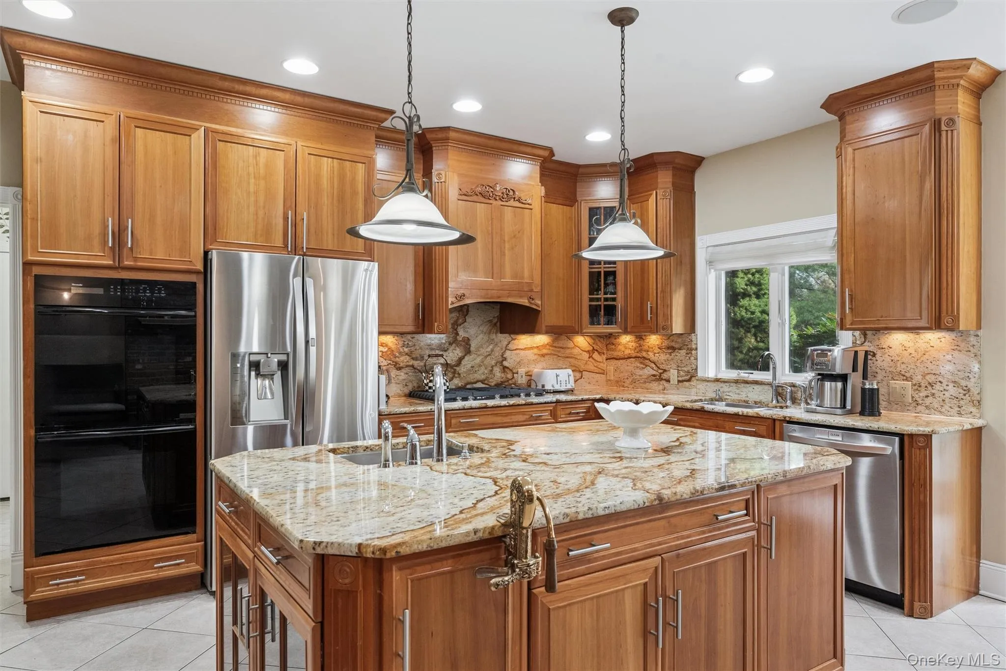 Kitchen featuring light tile patterned floors, brown cabinetry, light stone countertops, appliances with stainless steel finishes, and recessed lighting Kitchen featuring light tile patterned floors, brown cabinetry, light stone countertops, appliances with stainless steel finishes, and recessed lighting