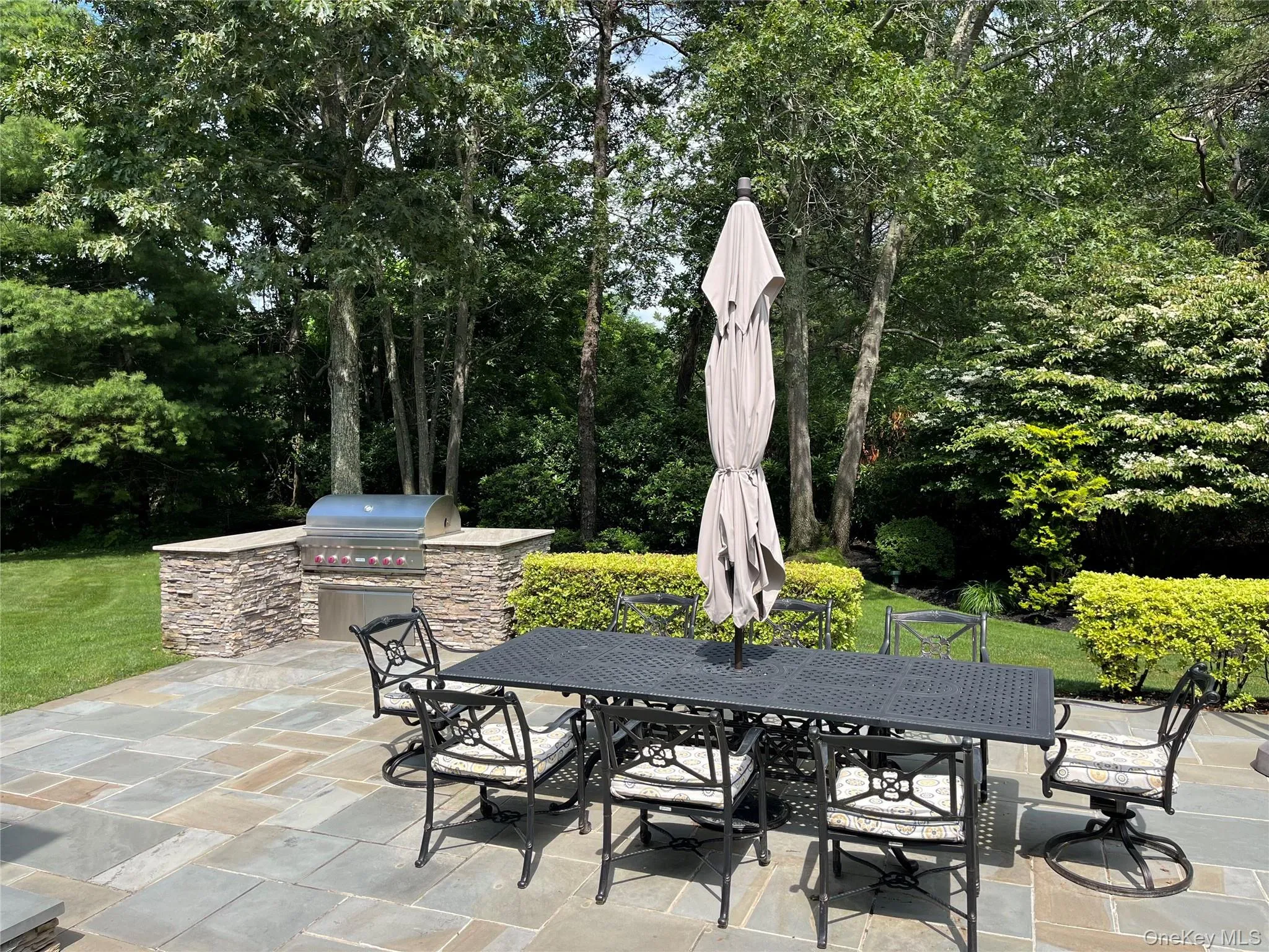 View of patio / terrace with outdoor dining space, an outdoor kitchen, and view of scattered trees View of patio / terrace with outdoor dining space, an outdoor kitchen, and view of scattered trees