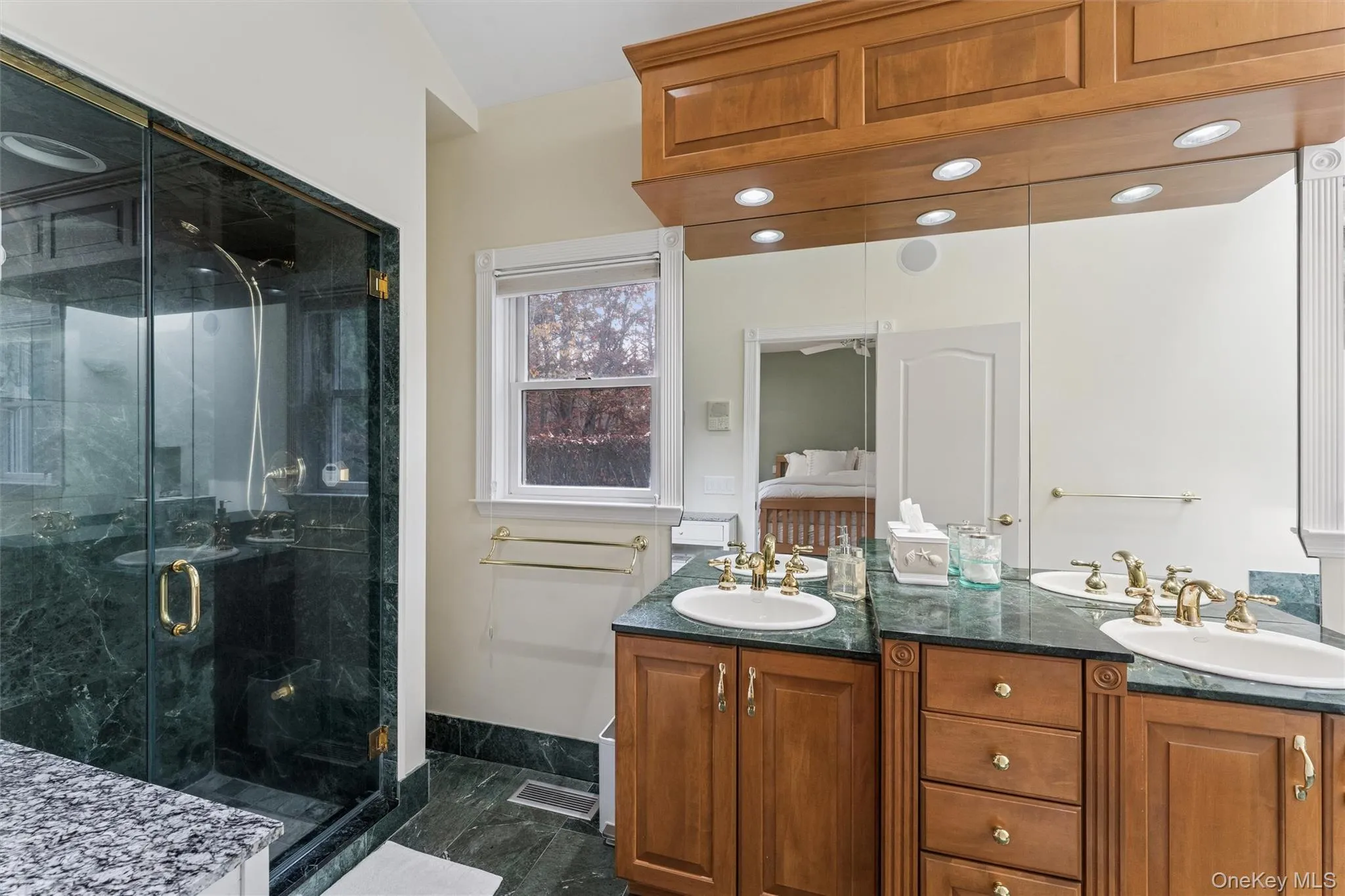 Full bathroom with double vanity and a marble finish shower Full bathroom with double vanity and a marble finish shower