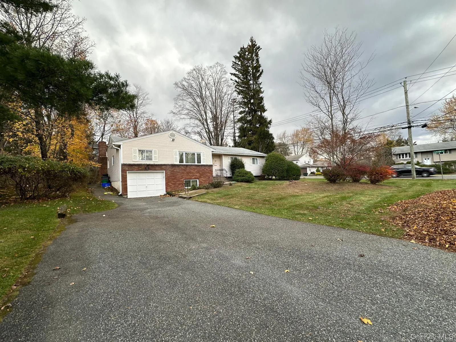 View of front of property with driveway, a front yard, an attached garage, and brick siding View of front of property with driveway, a front yard, an attached garage, and brick siding