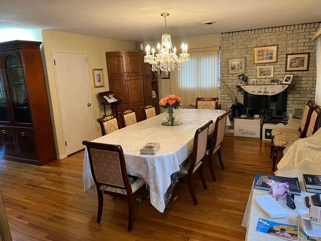 Dining room with dark wood-type flooring and a chandelier Dining room with dark wood-type flooring and a chandelier