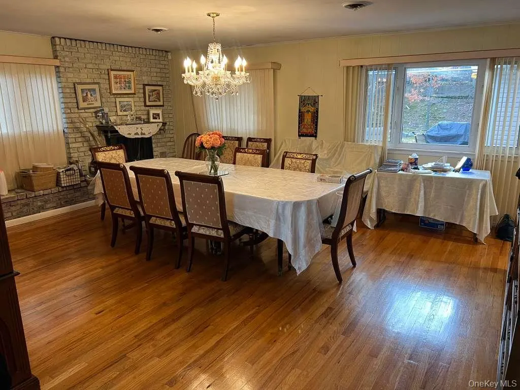 Dining room featuring dark wood-style flooring and a chandelier Dining room featuring dark wood-style flooring and a chandelier