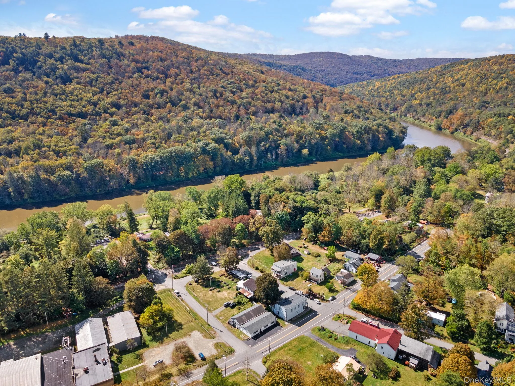 Aerial view of property and surrounding area with a water and mountain view and a heavily wooded area Aerial view of property and surrounding area with a water and mountain view and a heavily wooded area
