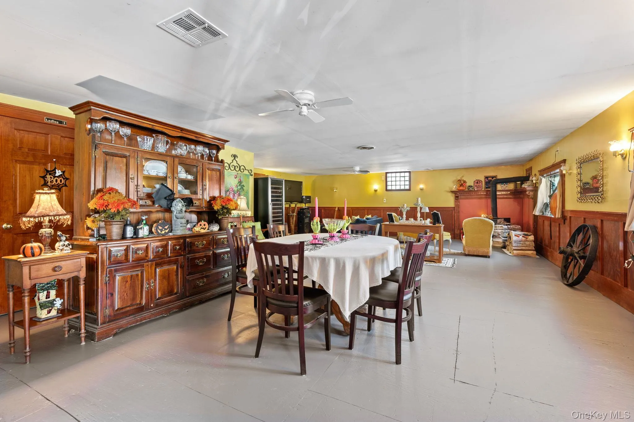 Dining space featuring a wainscoted wall, wooden walls, and ceiling fan Dining space featuring a wainscoted wall, wooden walls, and ceiling fan