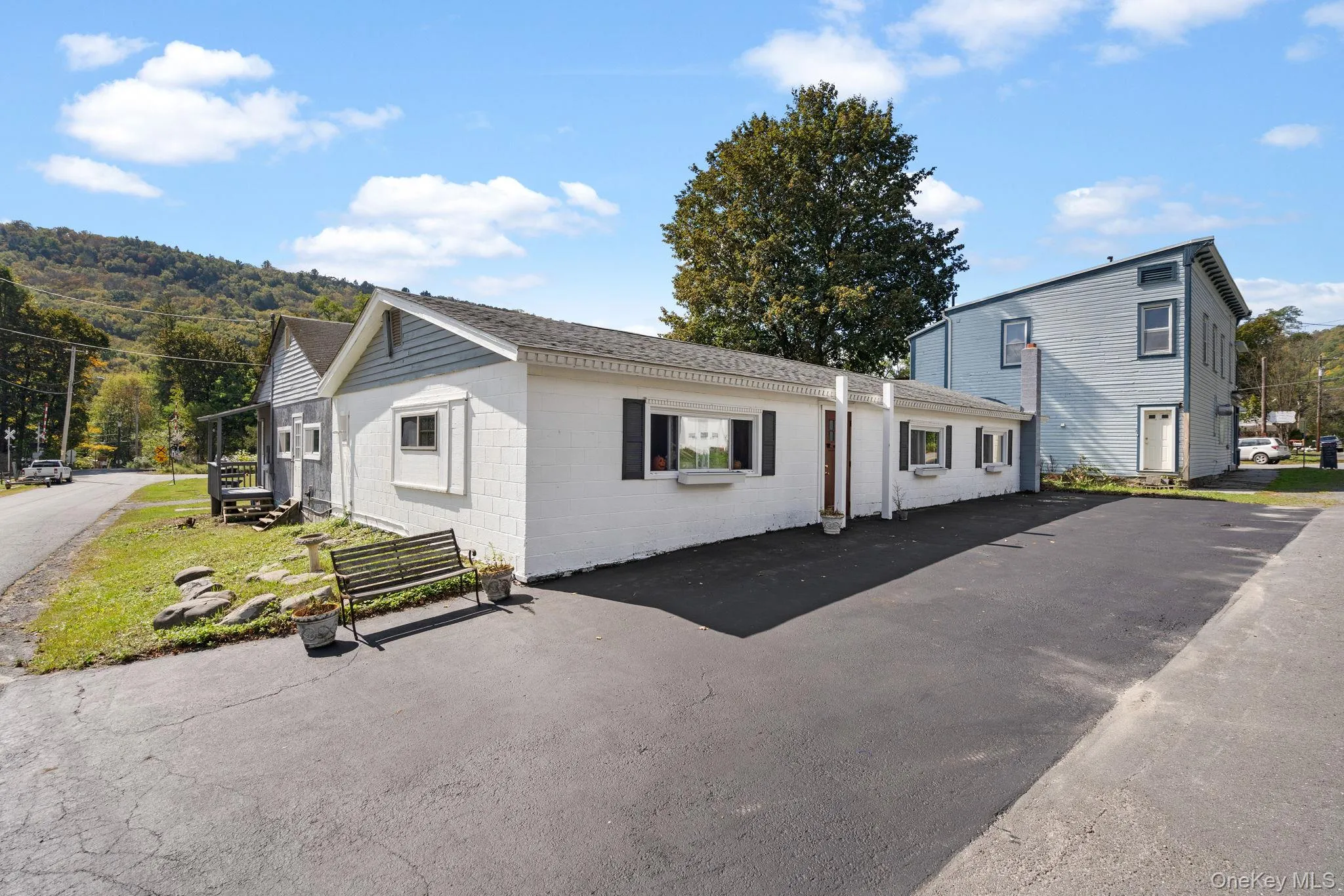 View of front of property with concrete block siding and a shingled roof View of front of property with concrete block siding and a shingled roof