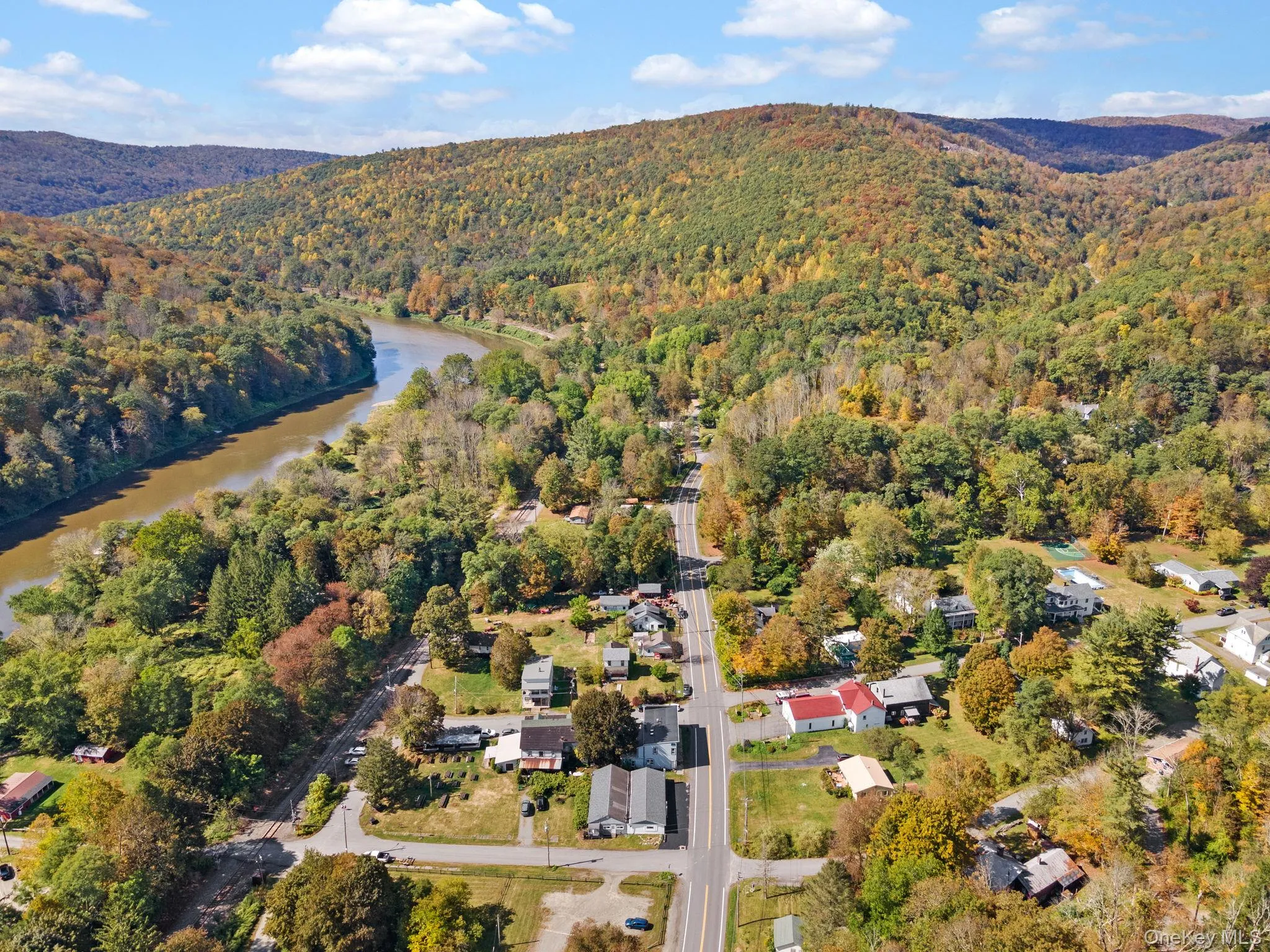 Aerial view of property and surrounding area featuring a forest and a water and mountain view Aerial view of property and surrounding area featuring a forest and a water and mountain view