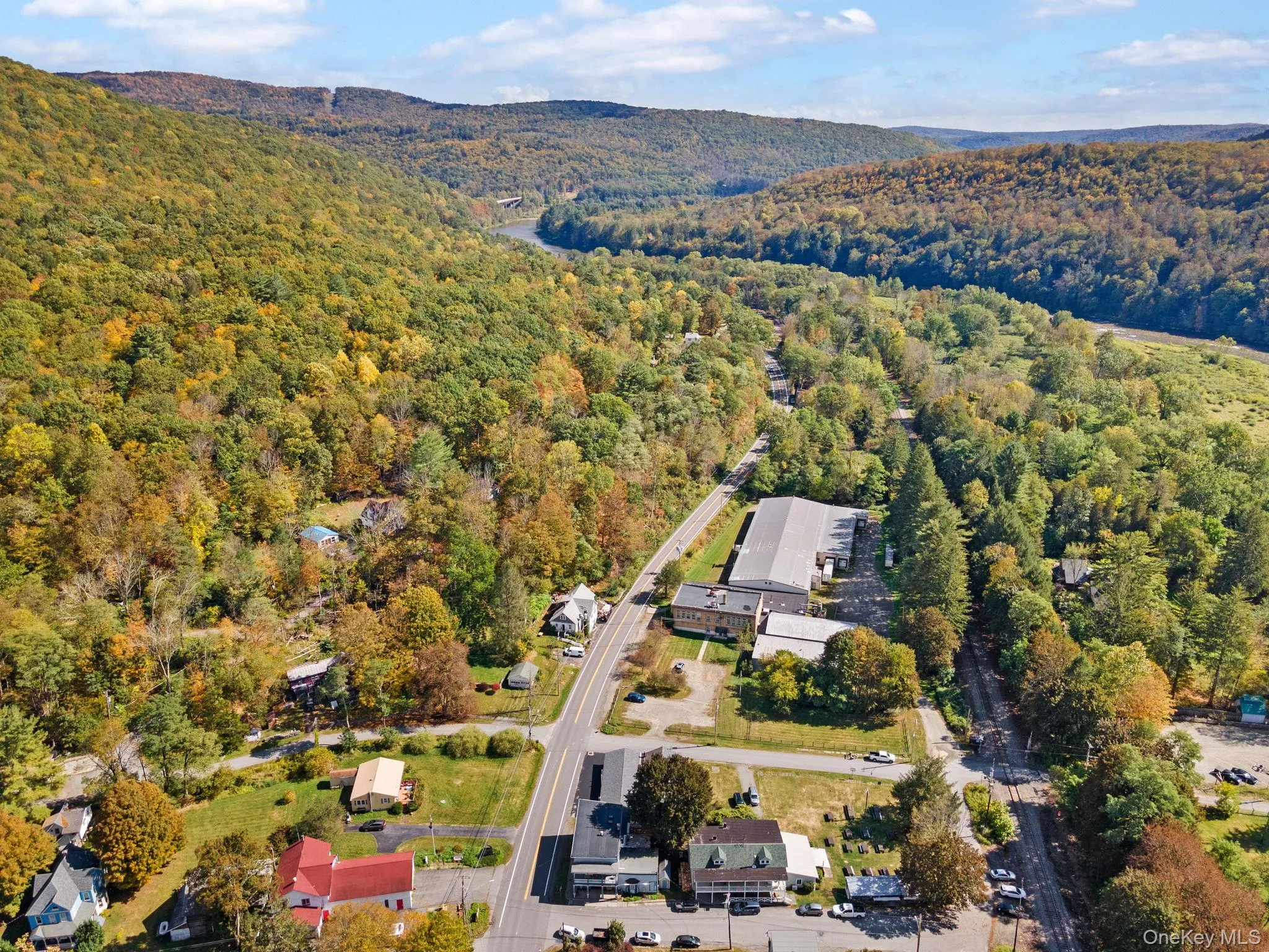 Aerial overview of property's location featuring a heavily wooded area and a mountainous background Aerial overview of property's location featuring a heavily wooded area and a mountainous background