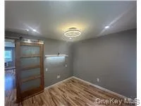 Empty room featuring a barn door and wood finished floors Empty room featuring a barn door and wood finished floors